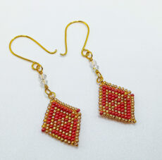 Beaded earrings in red and gold flat-lay