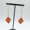 red and gold earrings on prop